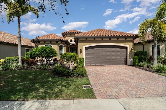 mediterranean / spanish house with a garage and a front lawn