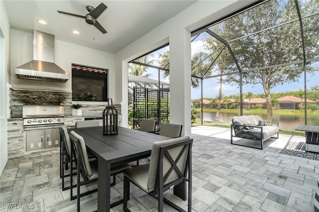 exterior space featuring a lanai, exterior kitchen, a water view, area for grilling, and ceiling fan