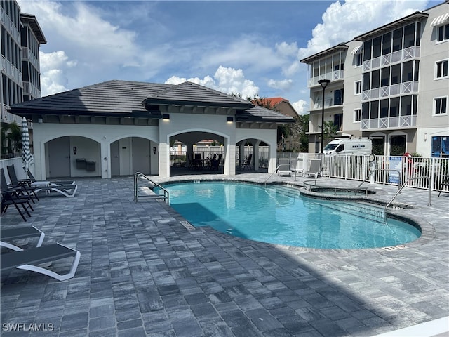 view of swimming pool with a patio area and a hot tub