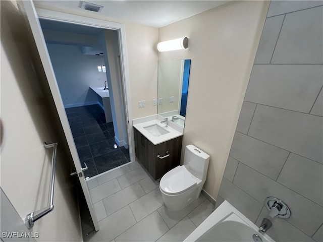 bathroom featuring tile patterned flooring, vanity, toilet, and a washtub