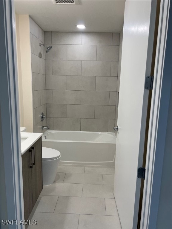 full bathroom featuring tile patterned flooring, vanity, toilet, and tiled shower / bath combo