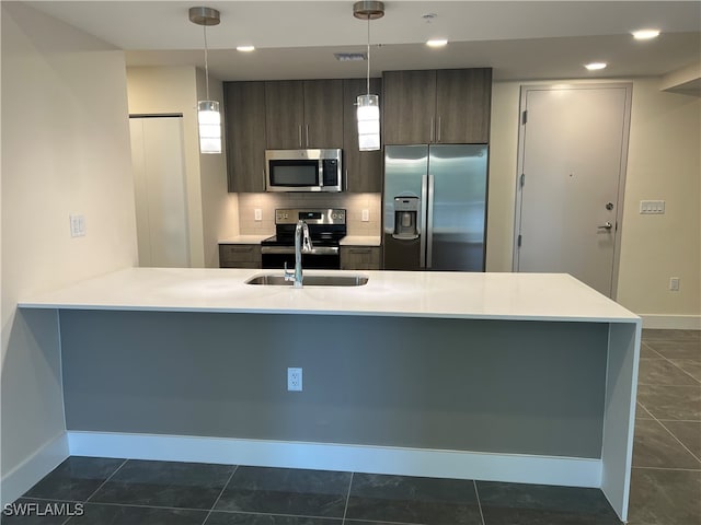 kitchen with appliances with stainless steel finishes, hanging light fixtures, dark brown cabinets, and sink