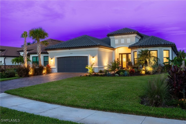 mediterranean / spanish-style house with a garage and a lawn