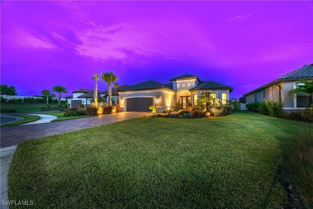 view of front of home featuring a garage and a yard