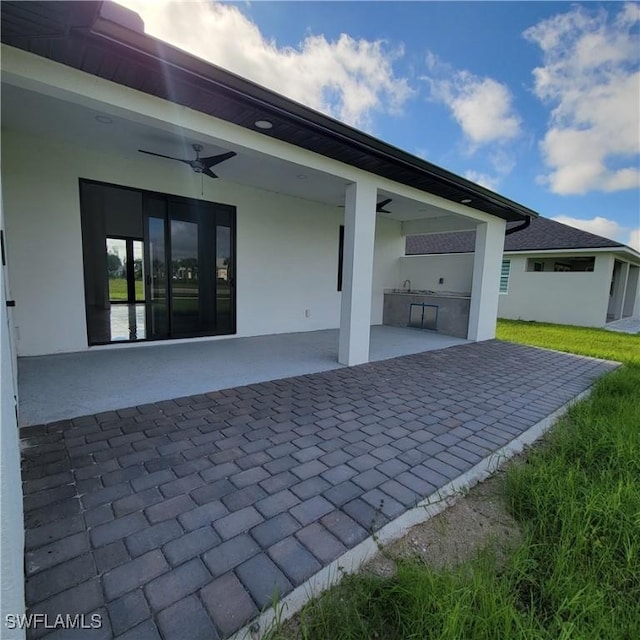 view of patio featuring ceiling fan and exterior kitchen