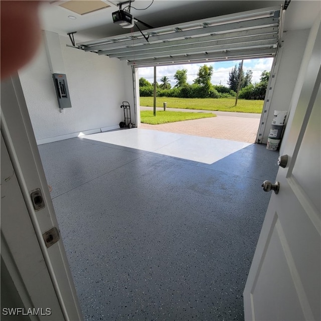 garage with electric panel, a lawn, and a garage door opener