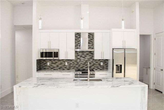 kitchen with stainless steel appliances, white cabinets, decorative backsplash, and wall chimney exhaust hood