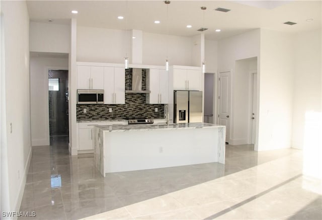 kitchen with stainless steel appliances, marble finish floor, white cabinets, and a center island with sink