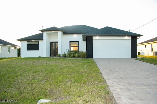 prairie-style home with a garage, a shingled roof, decorative driveway, a front lawn, and stucco siding