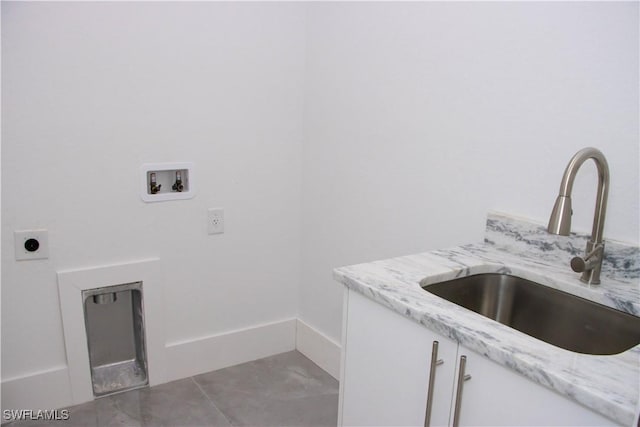 washroom featuring hookup for a washing machine, cabinet space, hookup for an electric dryer, a sink, and tile patterned floors