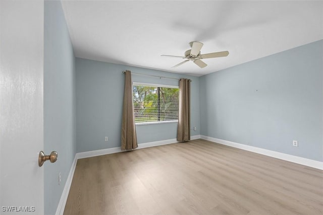 unfurnished room with ceiling fan, baseboards, and wood finished floors