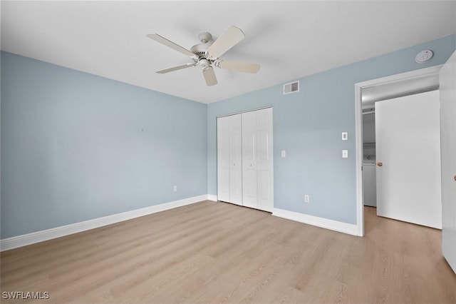 unfurnished bedroom featuring a closet, visible vents, baseboards, and wood finished floors