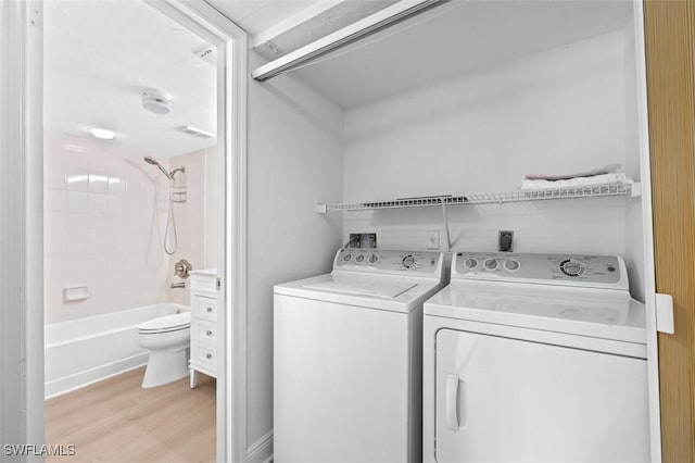 laundry room featuring light wood-type flooring, laundry area, and separate washer and dryer