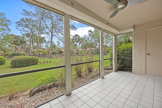 unfurnished sunroom featuring ceiling fan