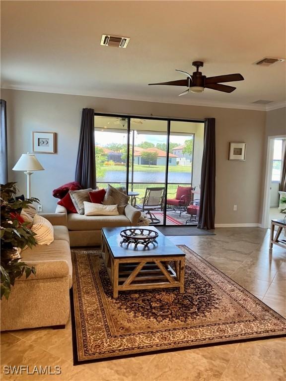 tiled living room with ceiling fan and ornamental molding