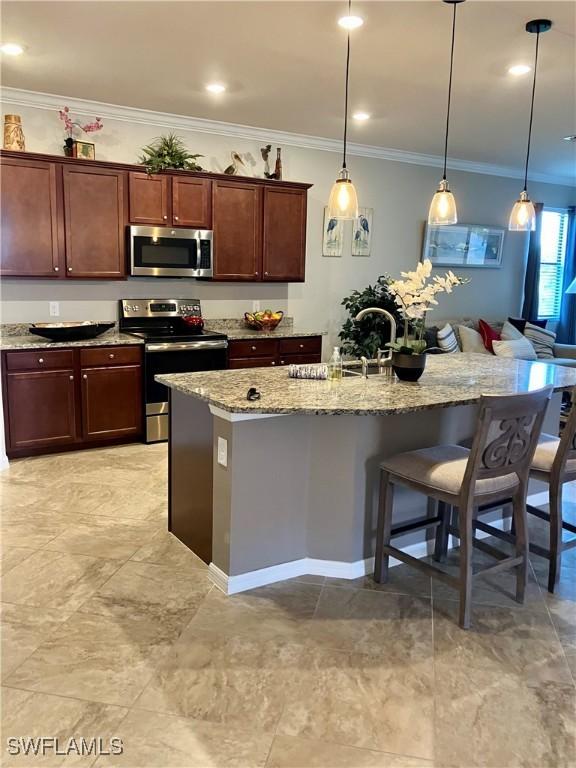 kitchen with a sink, a kitchen breakfast bar, appliances with stainless steel finishes, light stone countertops, and crown molding