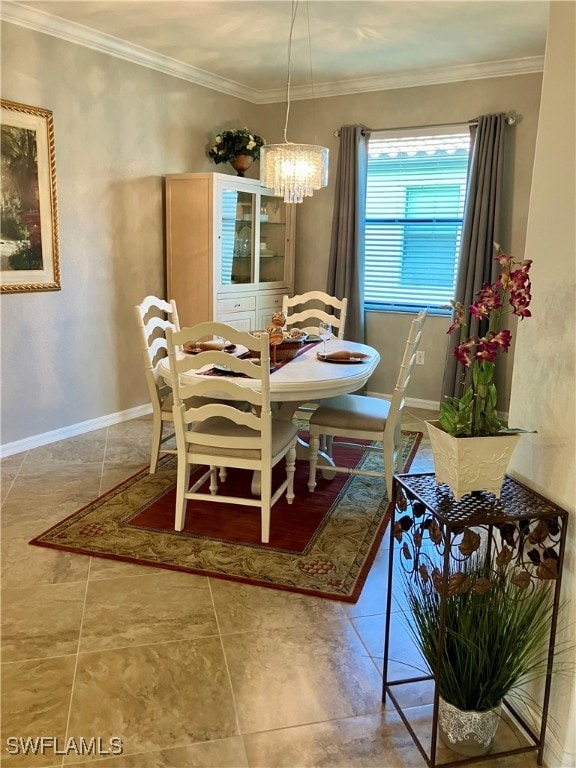 dining space with tile patterned floors, ornamental molding, and an inviting chandelier