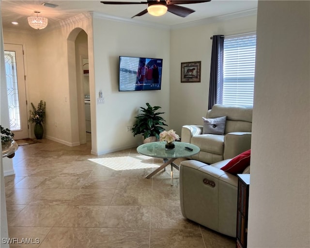 living room with washer / clothes dryer, crown molding, and ceiling fan with notable chandelier