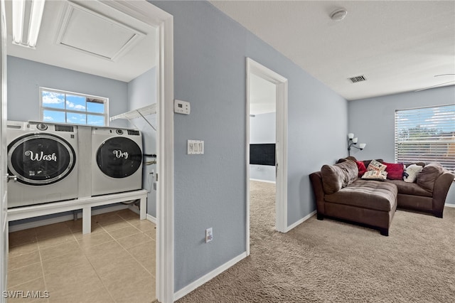 laundry room with light carpet, a healthy amount of sunlight, and separate washer and dryer