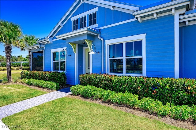 view of exterior entry with a yard