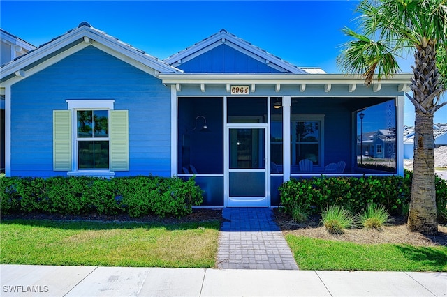 view of front of home with a front lawn and a sunroom