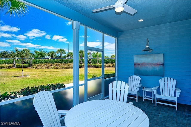 sunroom / solarium featuring ceiling fan