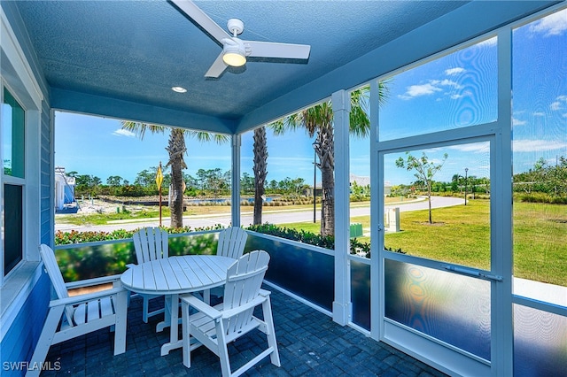 sunroom / solarium featuring plenty of natural light and ceiling fan