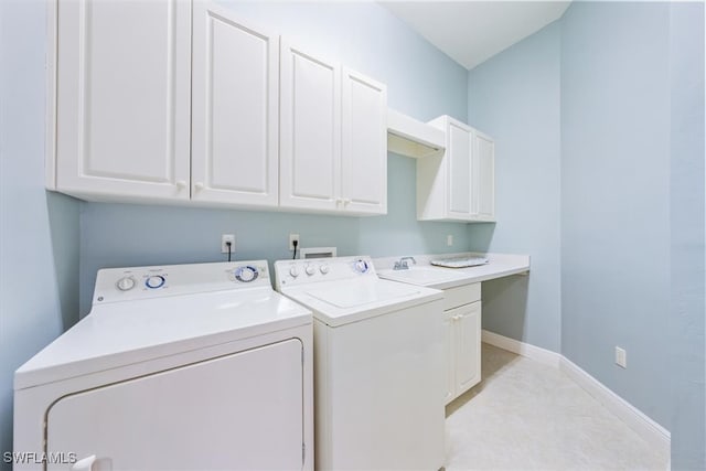 washroom with separate washer and dryer and cabinets