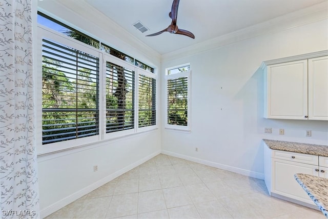 unfurnished dining area featuring crown molding, light tile patterned floors, and ceiling fan