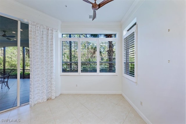 spare room featuring ceiling fan, ornamental molding, and light tile patterned floors