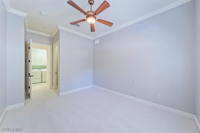 unfurnished room with ceiling fan, crown molding, light carpet, and washing machine and dryer