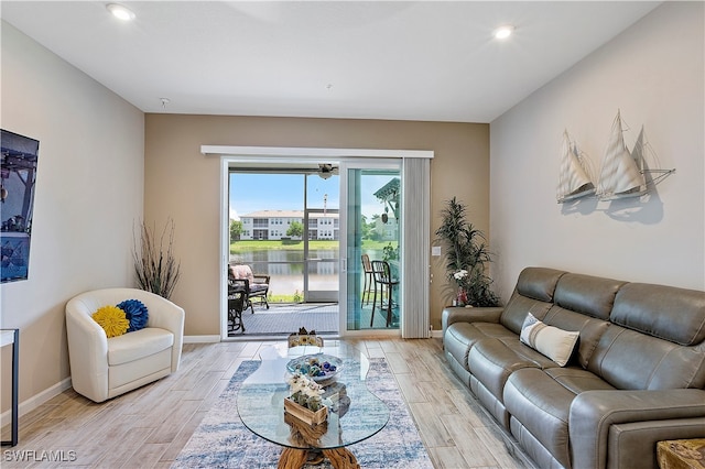 living room with light hardwood / wood-style floors and a water view