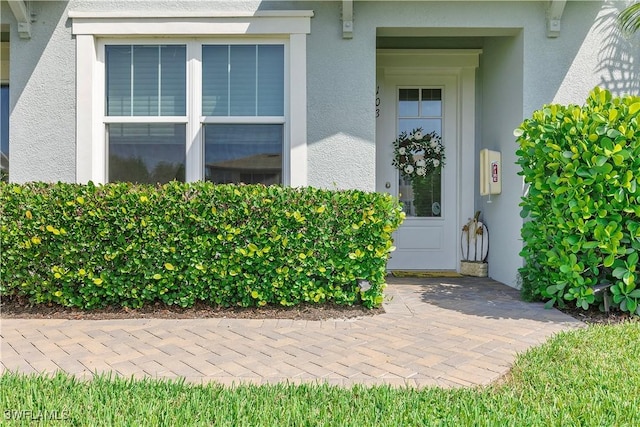 property entrance featuring stucco siding