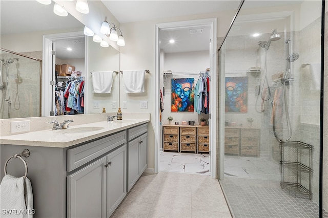 bathroom featuring a shower with door, vanity, and tile patterned flooring