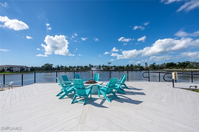 wooden terrace featuring a water view and an outdoor fire pit