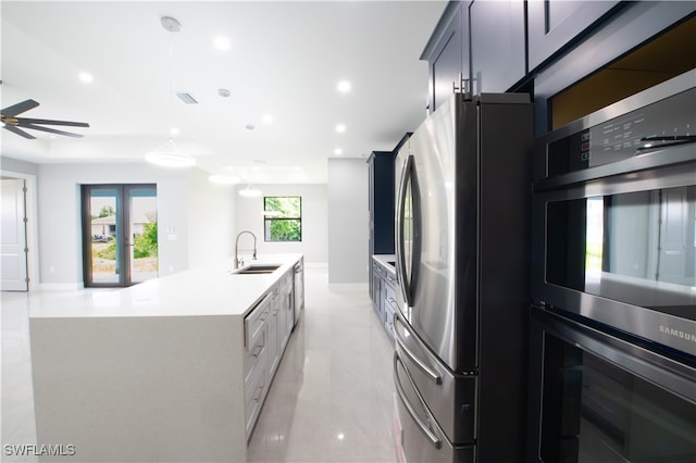 kitchen featuring a kitchen island with sink, appliances with stainless steel finishes, sink, and ceiling fan