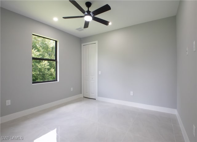 empty room with light tile patterned flooring and ceiling fan