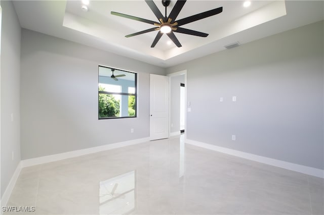 unfurnished room with a raised ceiling and ceiling fan