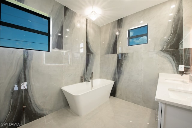 bathroom with tile walls, a washtub, and vanity