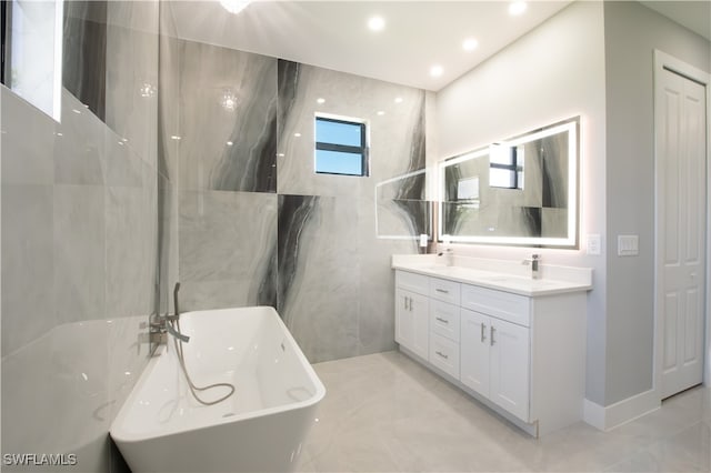 bathroom featuring vanity, plenty of natural light, and a bathtub