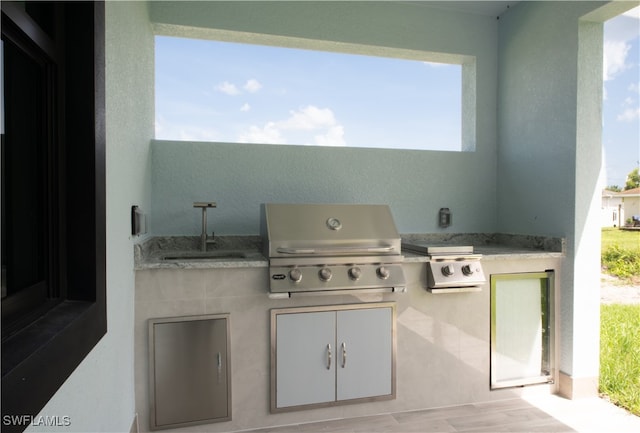 view of patio with exterior kitchen, sink, and area for grilling