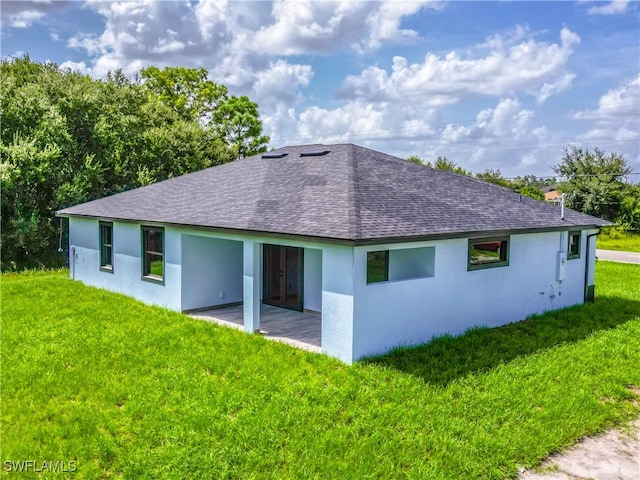 rear view of house with a yard and a patio