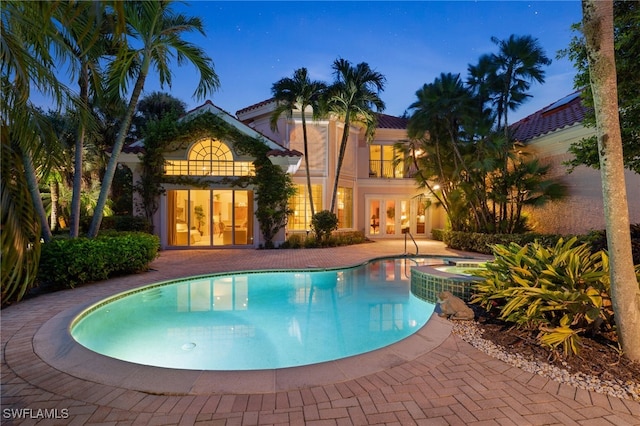 view of swimming pool with a patio and french doors