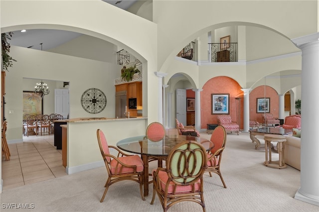 dining space featuring a notable chandelier, a high ceiling, and decorative columns