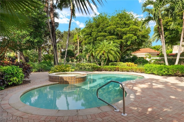 view of swimming pool with an in ground hot tub and a patio area