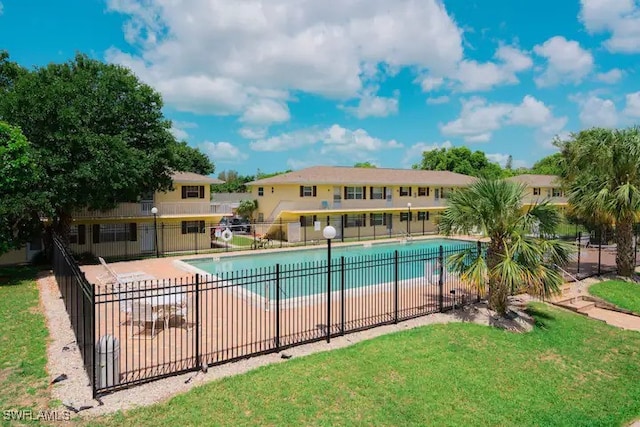 view of pool with a lawn