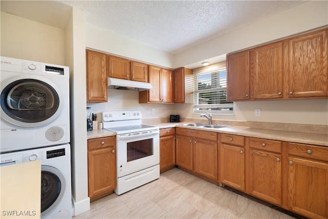 kitchen featuring stacked washing maching and dryer, a textured ceiling, electric range, and sink