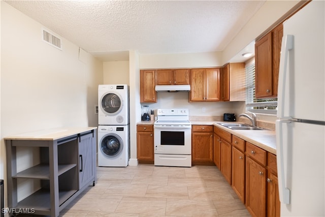 kitchen with a textured ceiling, white appliances, stacked washer and dryer, and sink