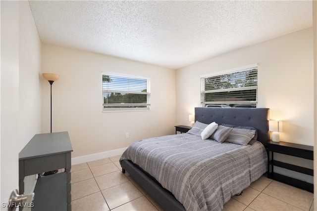 bedroom featuring a textured ceiling and light tile patterned floors