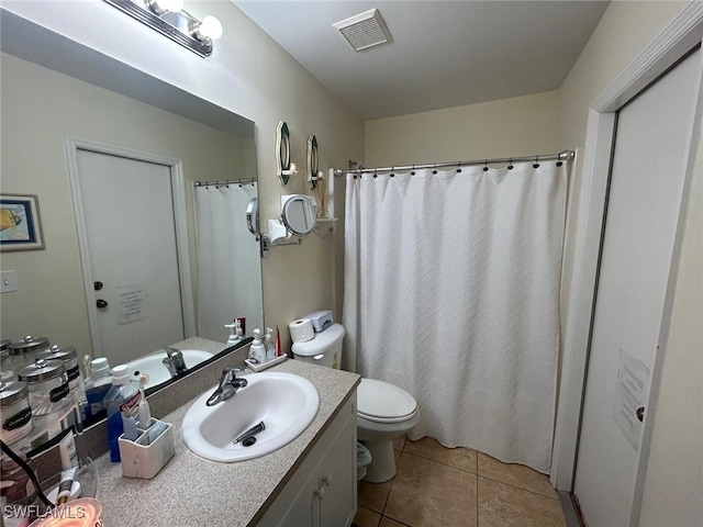 bathroom with tile patterned flooring, vanity, and toilet